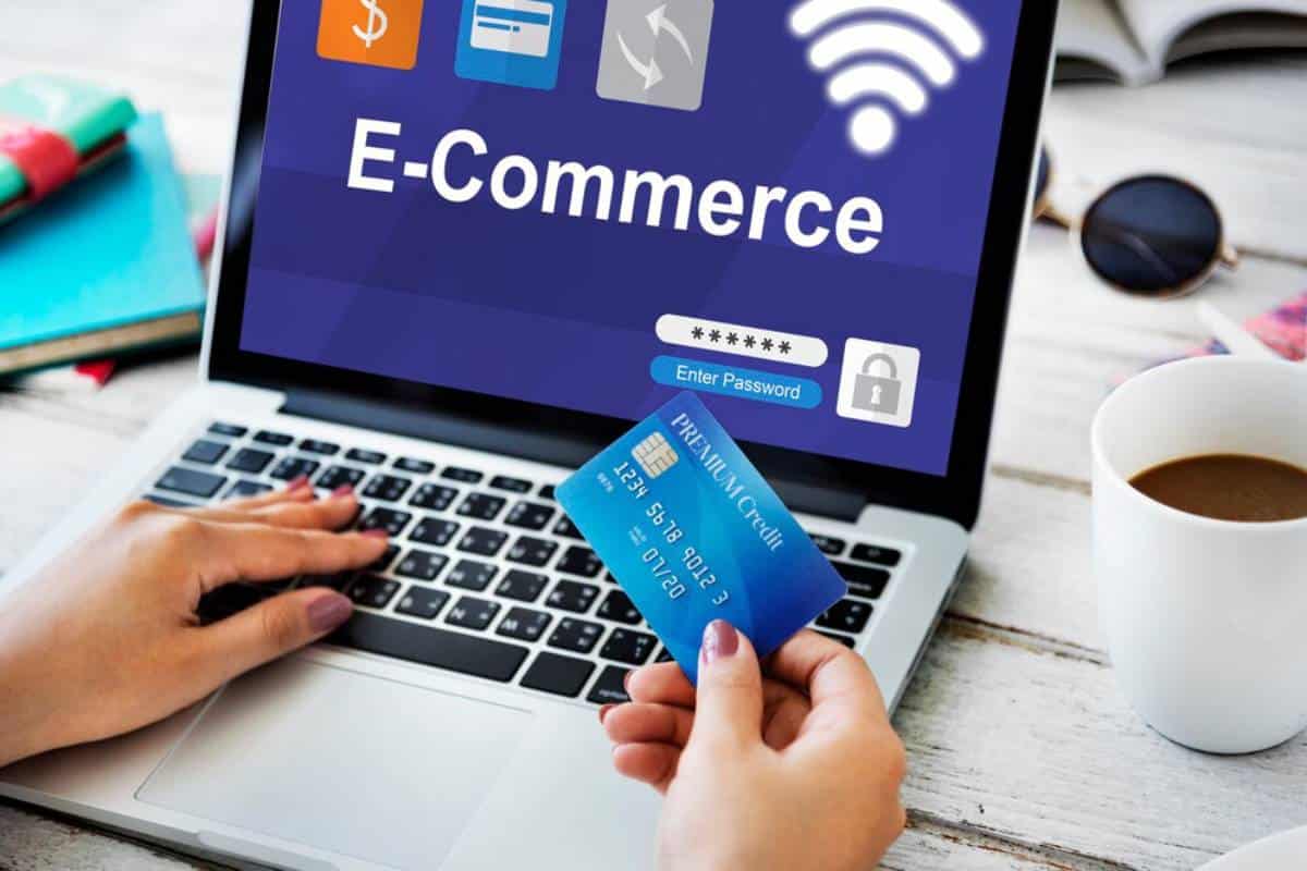 Person using a credit card to shop online on a laptop displaying an e-commerce website.