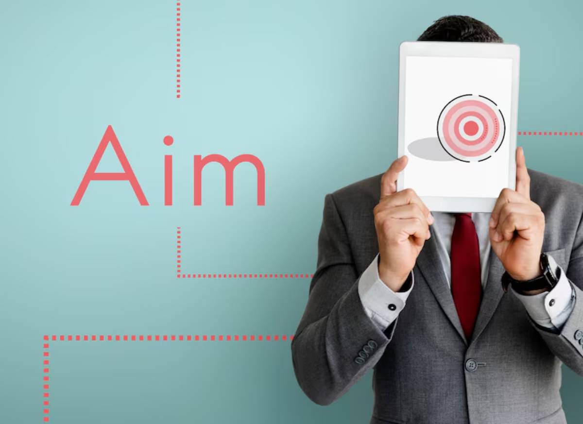 Man in suit holding a tablet in front of his face with a target symbol; large