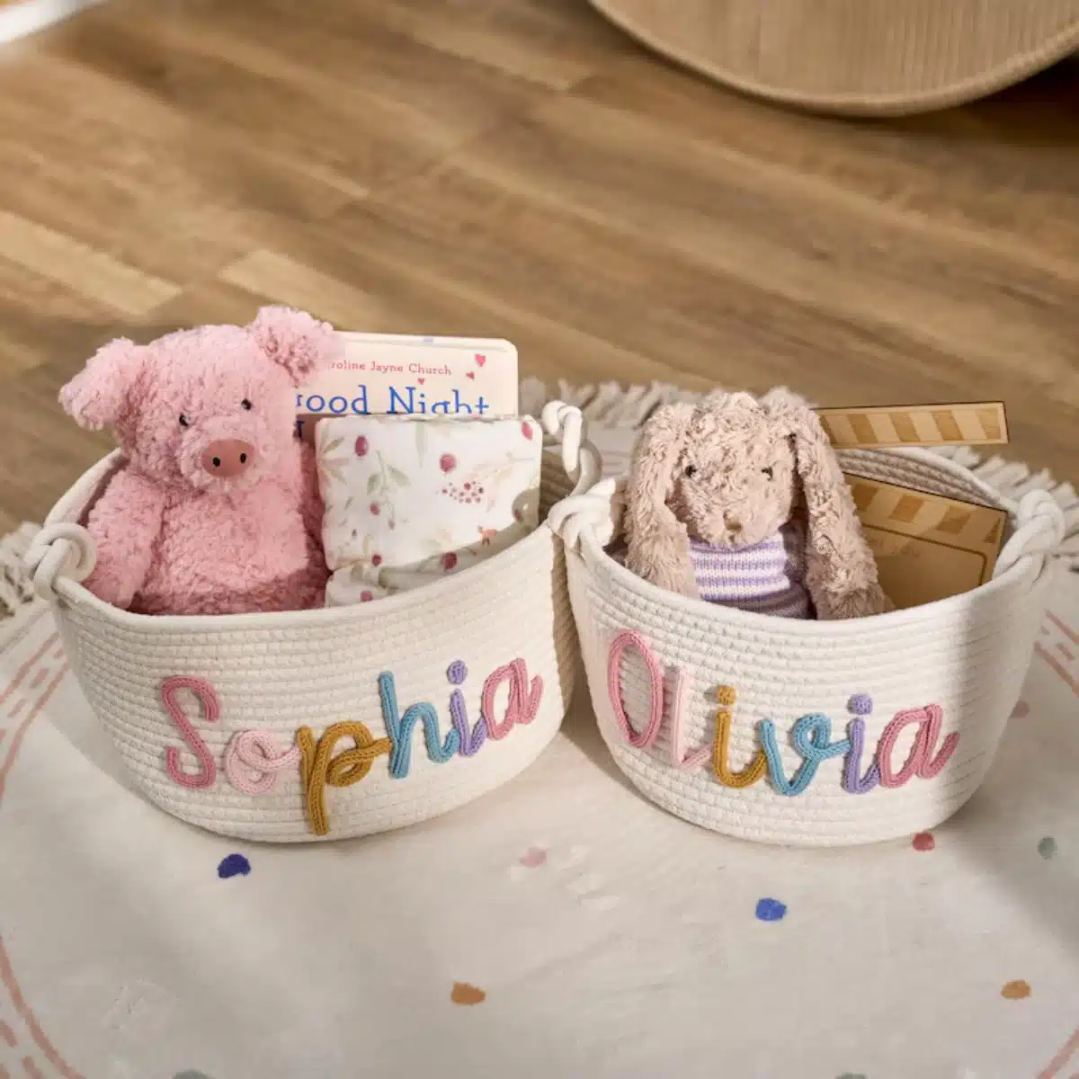 Two personalised storage baskets labelled Sophia and Olivia with a pink pig and a brown rabbit plush toy inside.