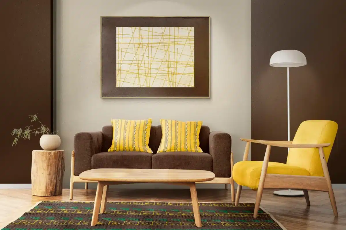 Modern living room with brown sofa, yellow accents, wooden furniture, and an abstract wall painting.