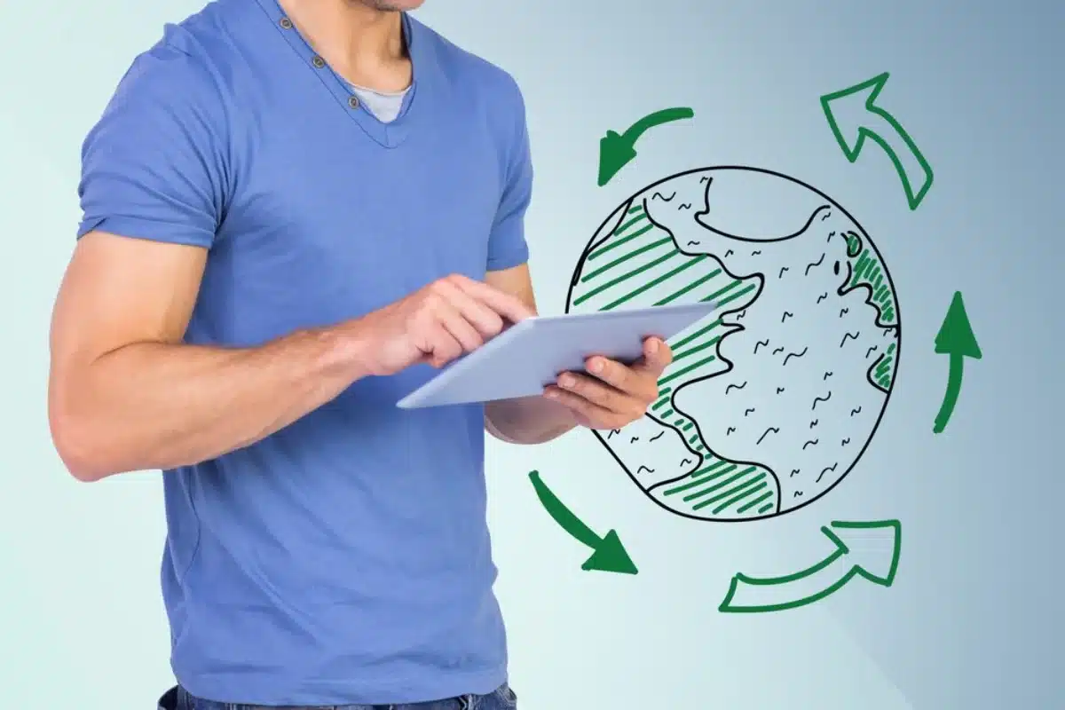 Man in blue t-shirt using a tablet with a graphic of a stylised Earth and recycling arrows overlay.